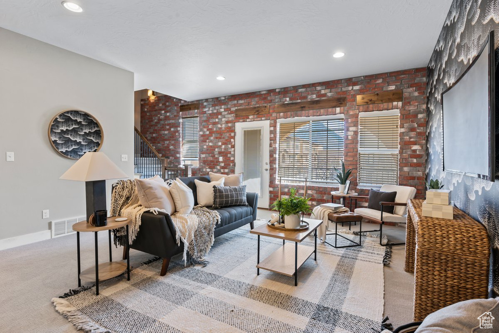 Living room with brick wall and light colored carpet