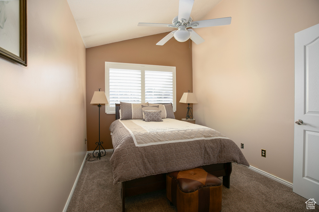 Bedroom featuring dark carpet, vaulted ceiling, and ceiling fan