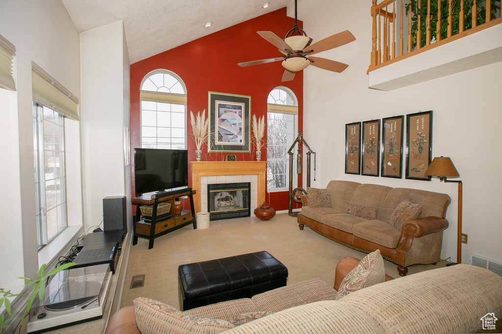 Living room with high vaulted ceiling, carpet, ceiling fan, and a fireplace