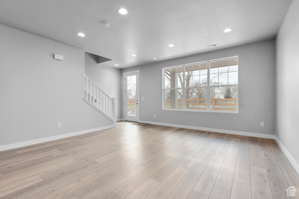 Spare room featuring light hardwood / wood-style floors and a wealth of natural light