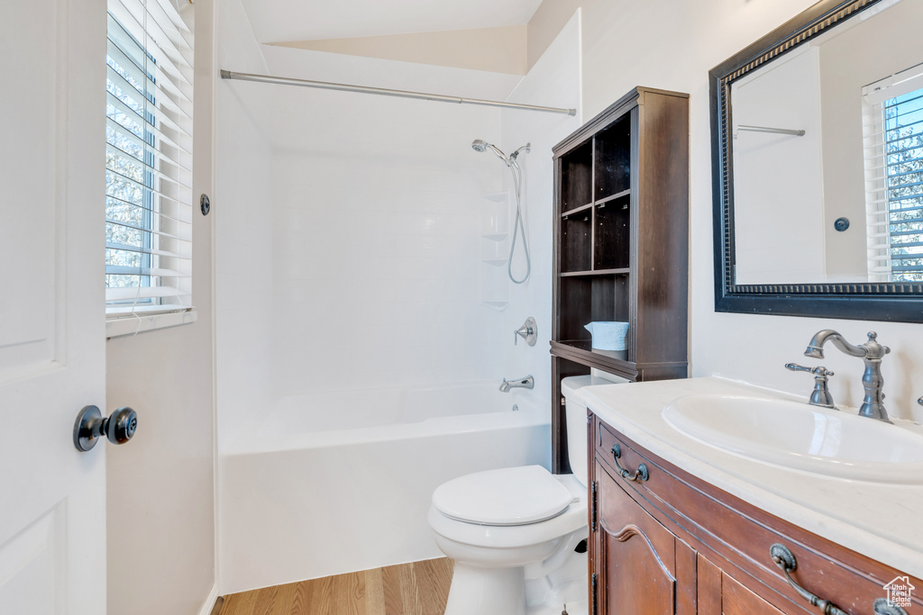 Full bathroom featuring a healthy amount of sunlight, vanity, toilet, and hardwood / wood-style flooring