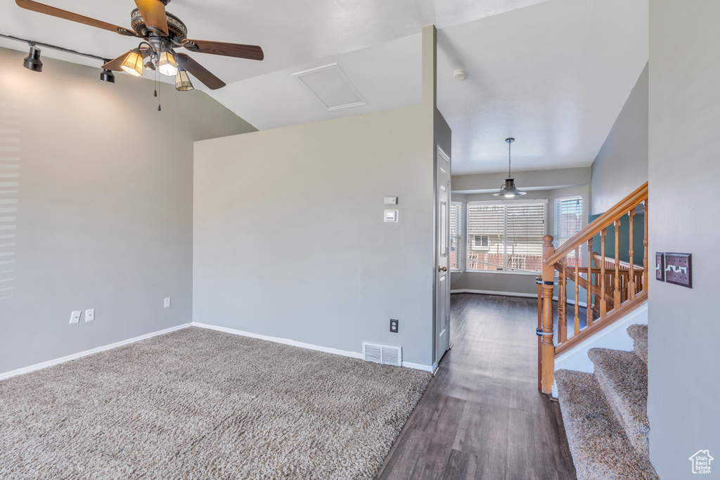 Living room featuring rail lighting, dark hardwood / wood-style floors, ceiling fan, and vaulted ceiling