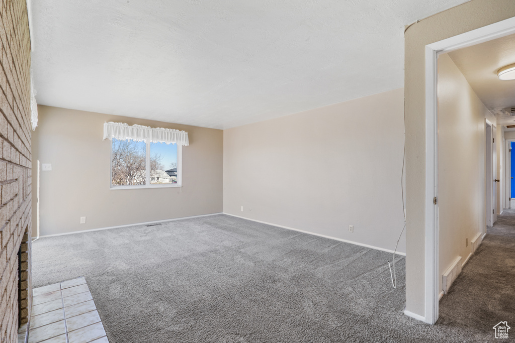 Carpeted empty room with a fireplace