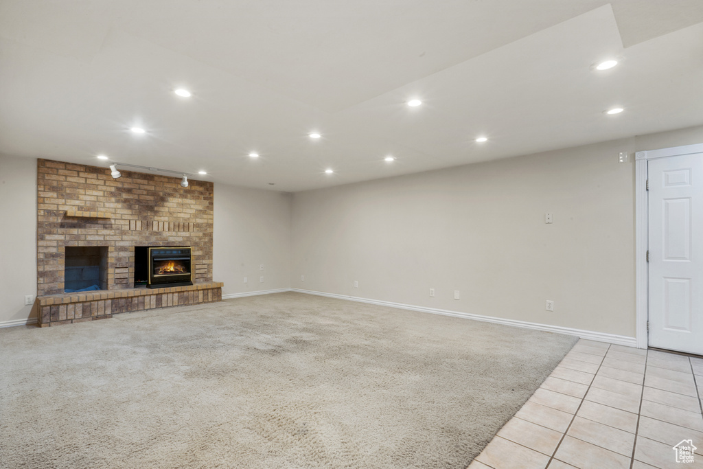 Unfurnished living room featuring light tile floors and a fireplace