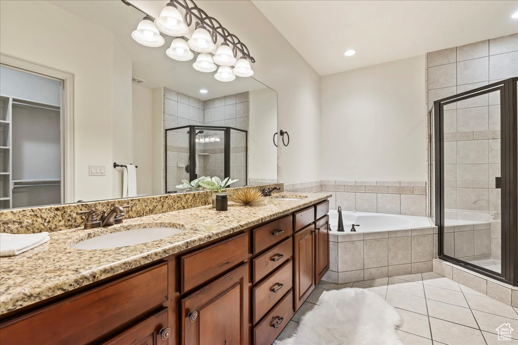Bathroom with double sink, tile flooring, large vanity, and separate shower and tub