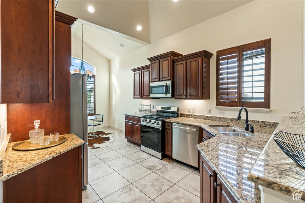 Kitchen featuring lofted ceiling, sink, stainless steel appliances, and plenty of natural light