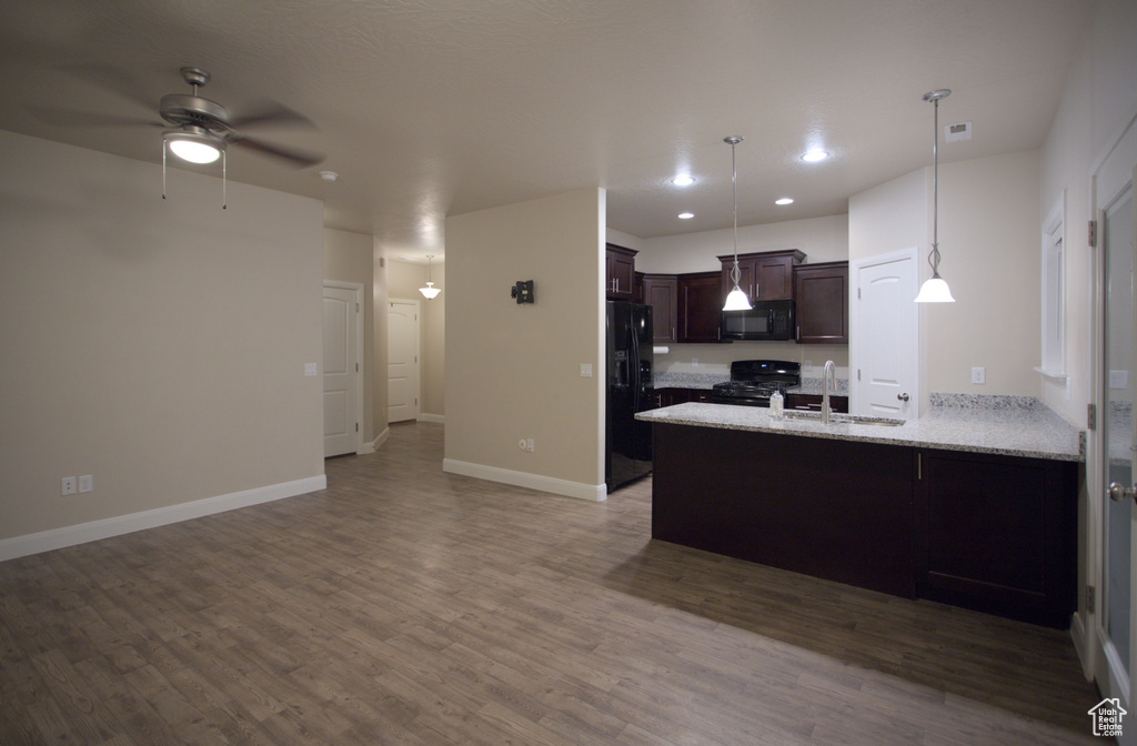 Kitchen featuring dark hardwood / wood-style floors, hanging light fixtures, ceiling fan, and black appliances