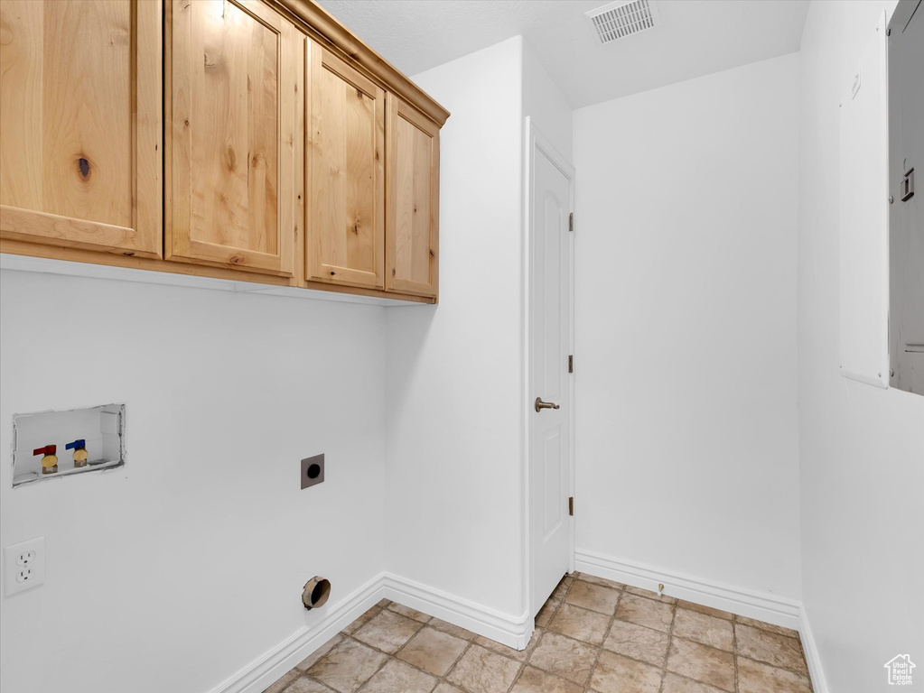 Laundry room with washer hookup, cabinets, light tile flooring, and electric dryer hookup