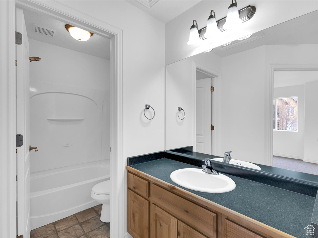 Full bathroom with shower / washtub combination, toilet, tile flooring, and vanity