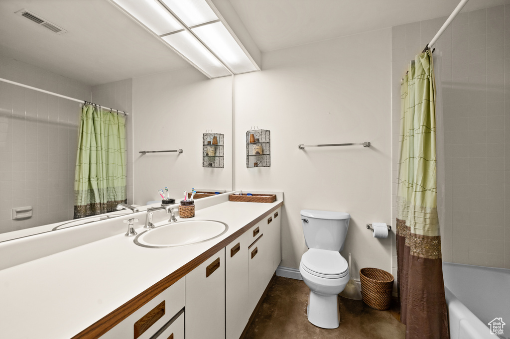 Full bathroom with toilet, large vanity, and shower / bath combination with curtain