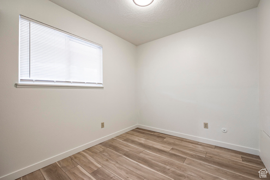Empty room featuring light hardwood / wood-style flooring and a wealth of natural light