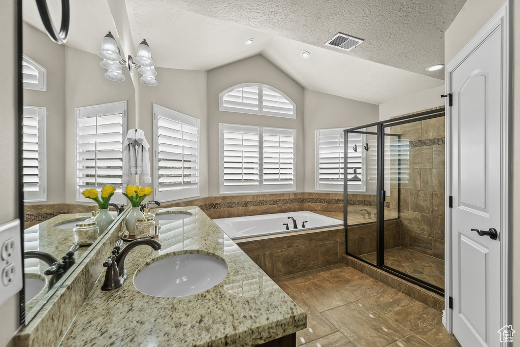 Bathroom with double sink vanity, tile floors, a textured ceiling, a chandelier, and separate shower and tub