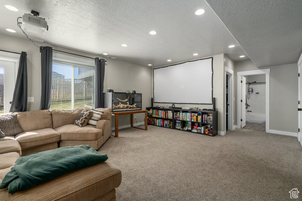 Carpeted cinema room with a textured ceiling