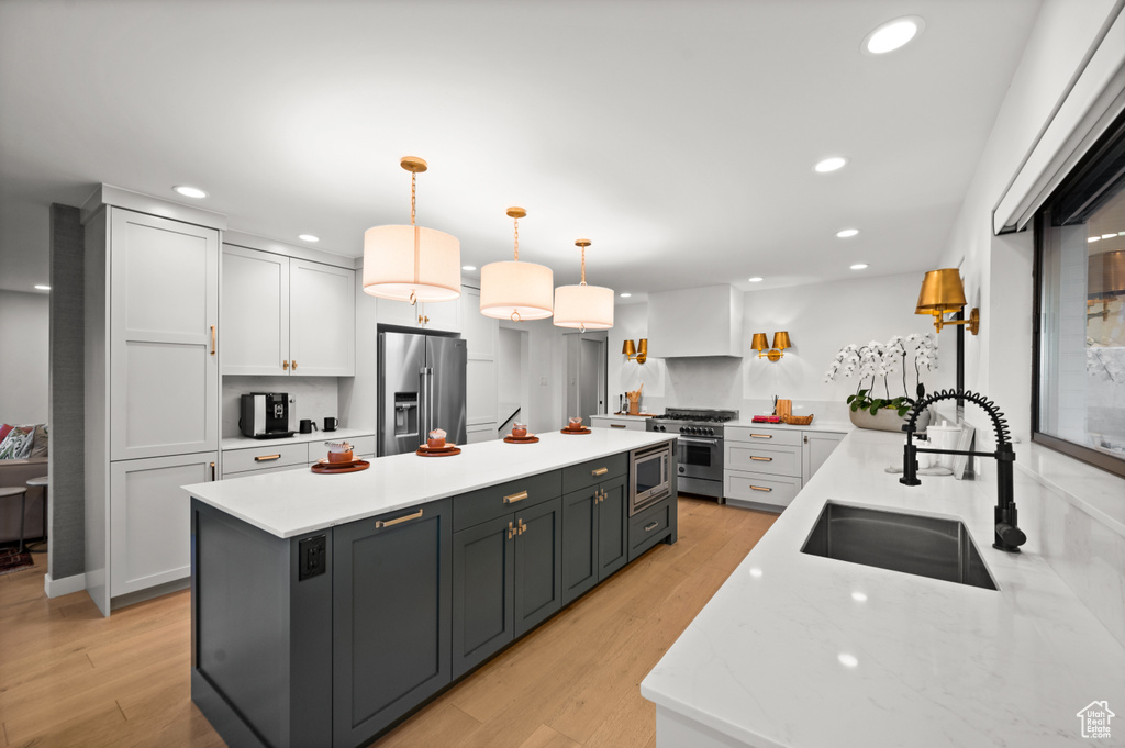 Kitchen with tasteful backsplash, a center island, high quality appliances, sink, and white cabinets
