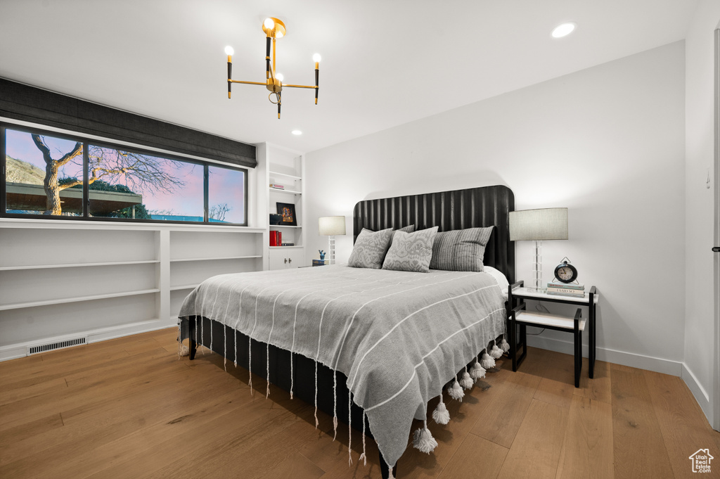 Bedroom with a notable chandelier and hardwood / wood-style flooring