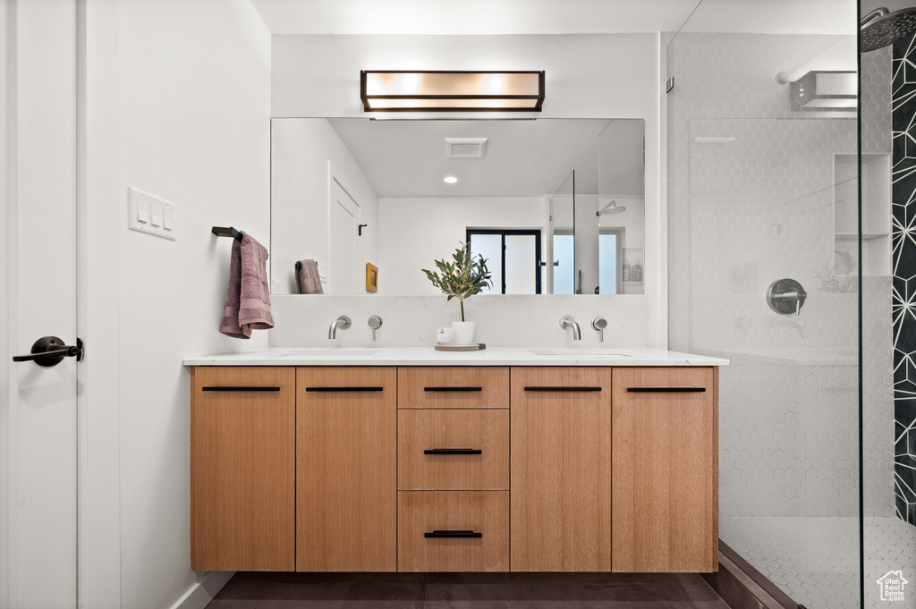 Bathroom with dual sinks, large vanity, and an enclosed shower