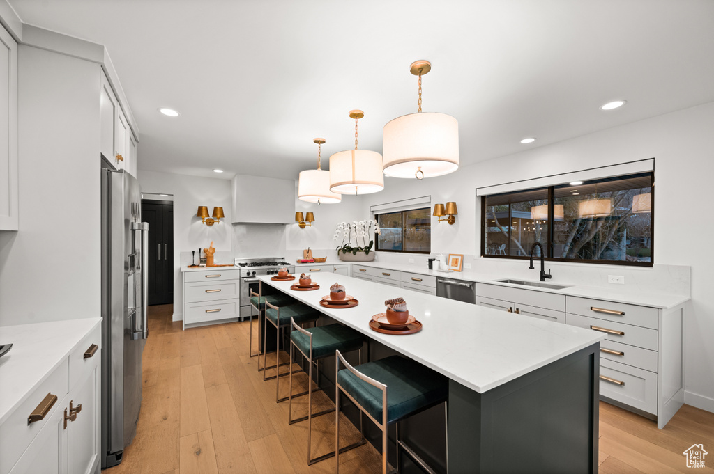 Kitchen featuring light hardwood / wood-style flooring, a kitchen bar, sink, and a center island