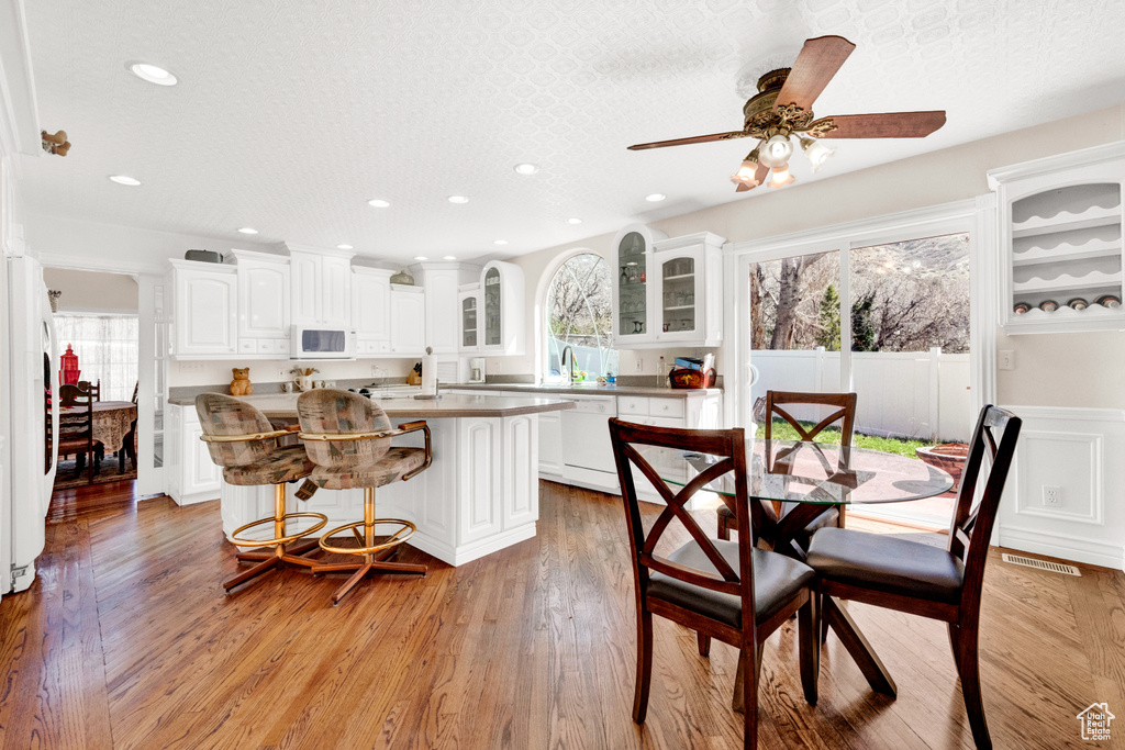 Dining space featuring ceiling fan, a textured ceiling, light hardwood / wood-style flooring, and sink