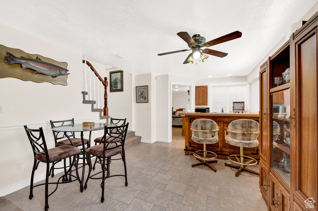 Tiled dining room featuring ceiling fan