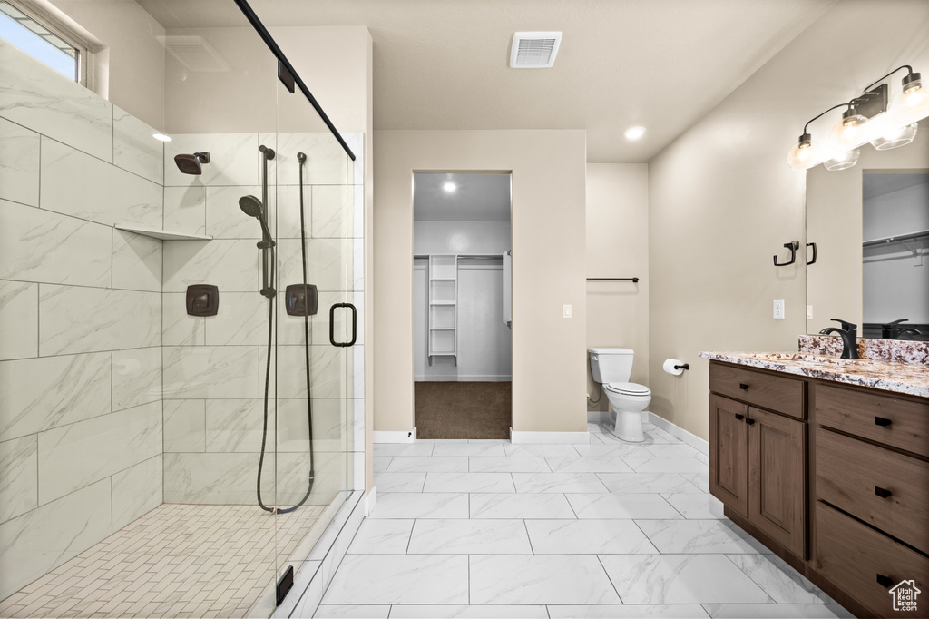 Bathroom featuring toilet, tile flooring, a shower with shower door, and oversized vanity