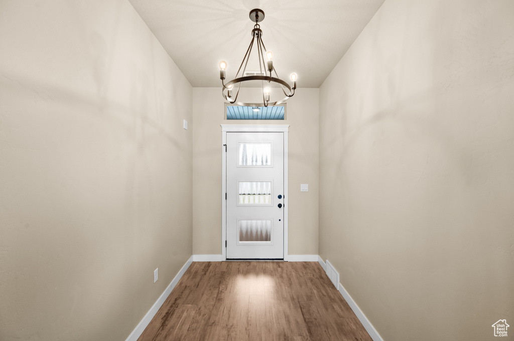 Entryway with a notable chandelier and wood-type flooring