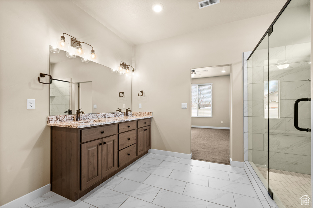 Bathroom with ceiling fan, tile flooring, walk in shower, and double vanity