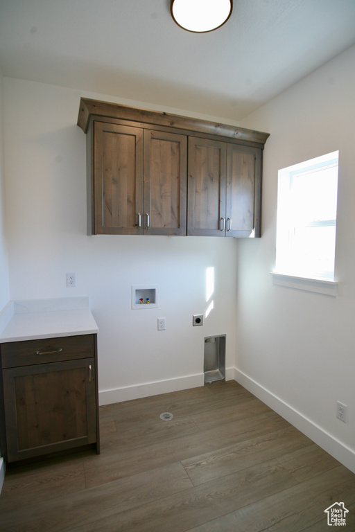 Washroom featuring cabinets, washer hookup, dark hardwood / wood-style floors, and hookup for an electric dryer