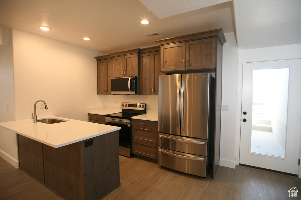 Kitchen with dark hardwood / wood-style flooring, appliances with stainless steel finishes, and sink