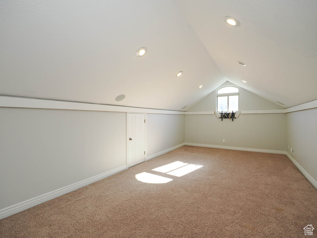 Bonus room featuring lofted ceiling and light carpet