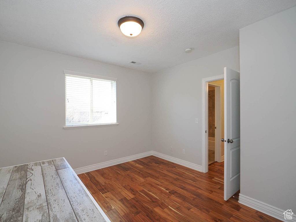 Unfurnished room featuring dark hardwood / wood-style floors