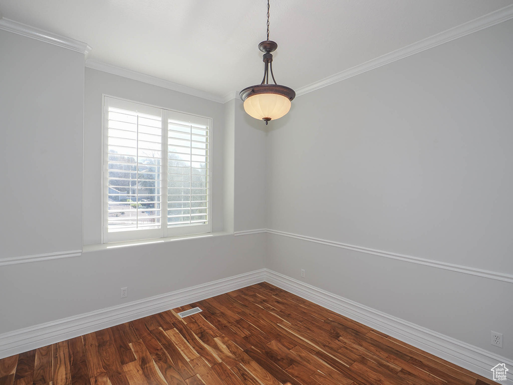 Unfurnished room with crown molding and dark hardwood / wood-style flooring