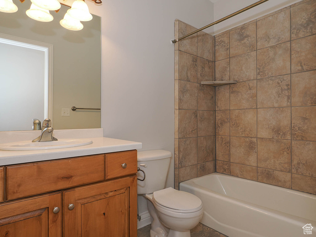 Full bathroom with tiled shower / bath combo, toilet, and vanity