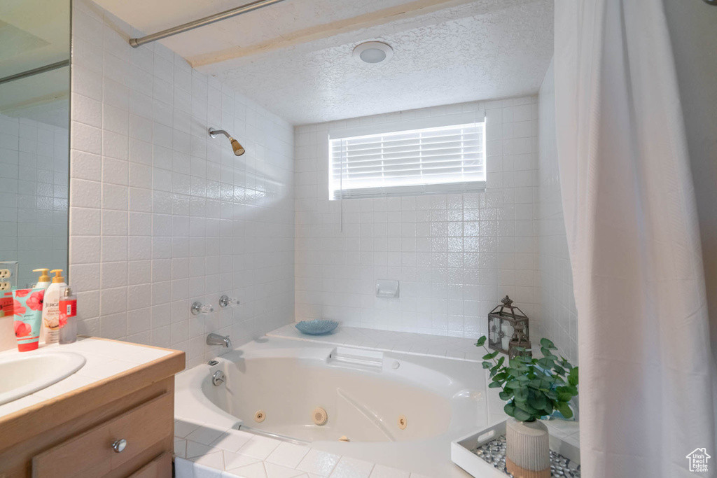 Bathroom with vanity, a textured ceiling, and shower / tub combo with curtain