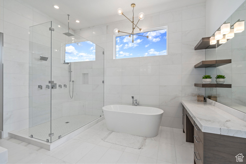 Bathroom featuring tile walls, a chandelier, tile floors, and plenty of natural light