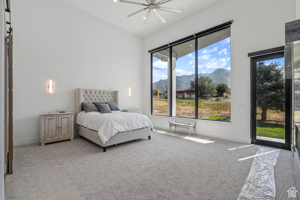 Bedroom with light carpet, a mountain view, ceiling fan, and access to outside