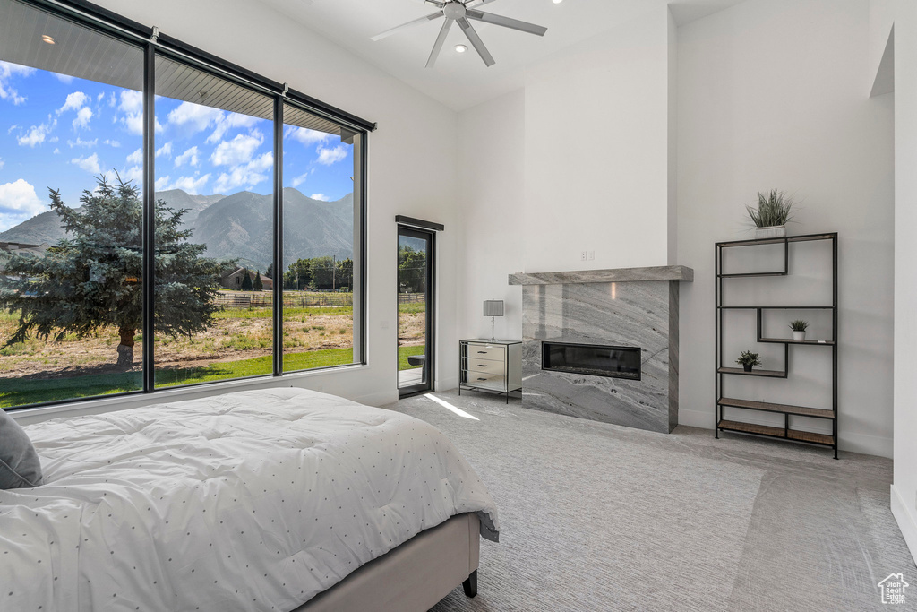 Carpeted bedroom with a mountain view, access to exterior, and ceiling fan
