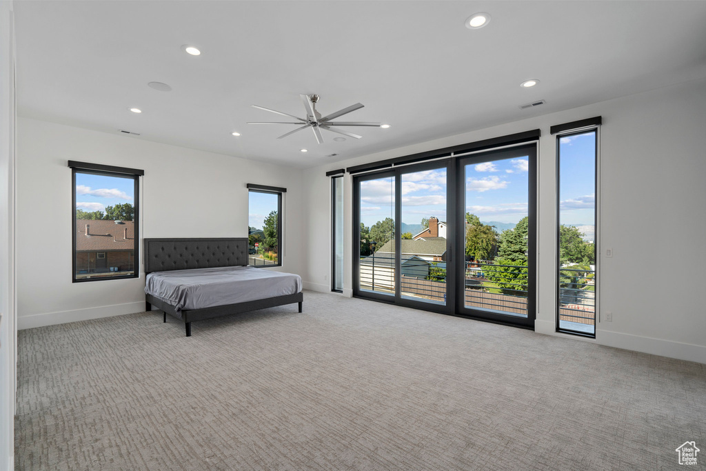 Bedroom featuring access to exterior, light colored carpet, and ceiling fan