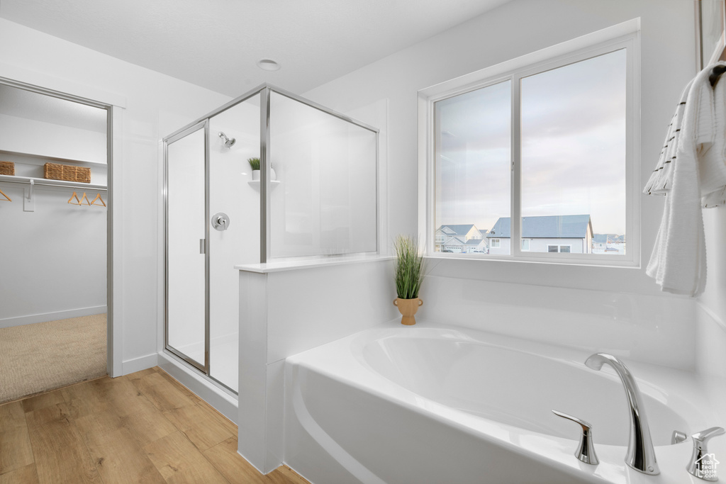 Bathroom featuring plus walk in shower and wood-type flooring