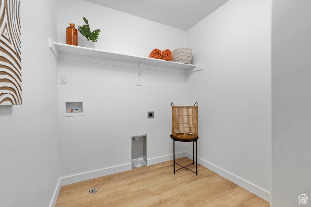 Washroom featuring washer hookup, light hardwood / wood-style floors, and electric dryer hookup