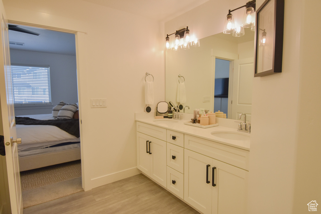 Bathroom featuring dual sinks, large vanity, and hardwood / wood-style flooring