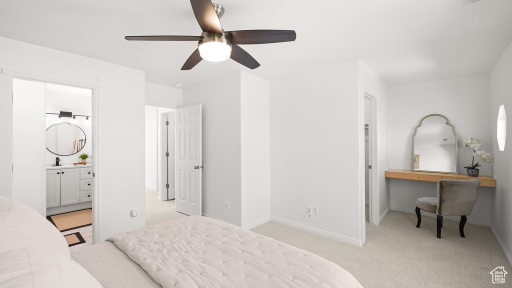 Bedroom with ceiling fan, sink, connected bathroom, and light carpet