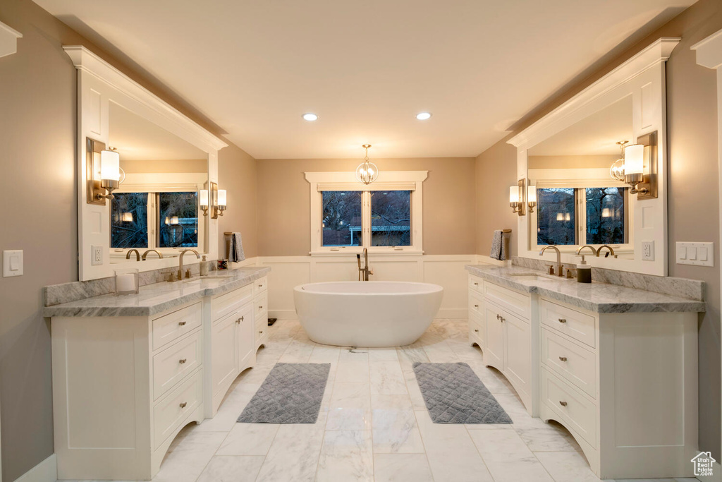 Bathroom with tile flooring, vanity, and a washtub