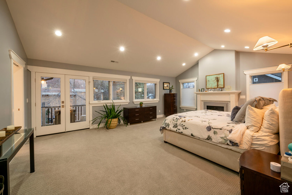 Carpeted bedroom featuring lofted ceiling, access to exterior, and french doors