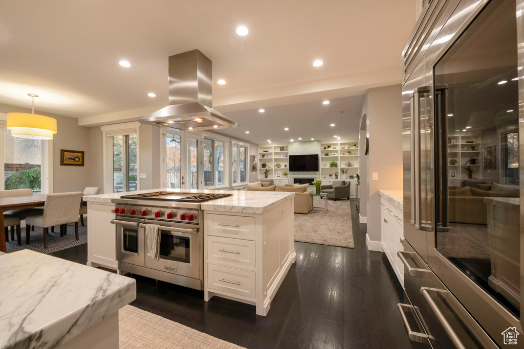 Kitchen featuring pendant lighting, white cabinets, stainless steel appliances, dark wood-type flooring, and island range hood