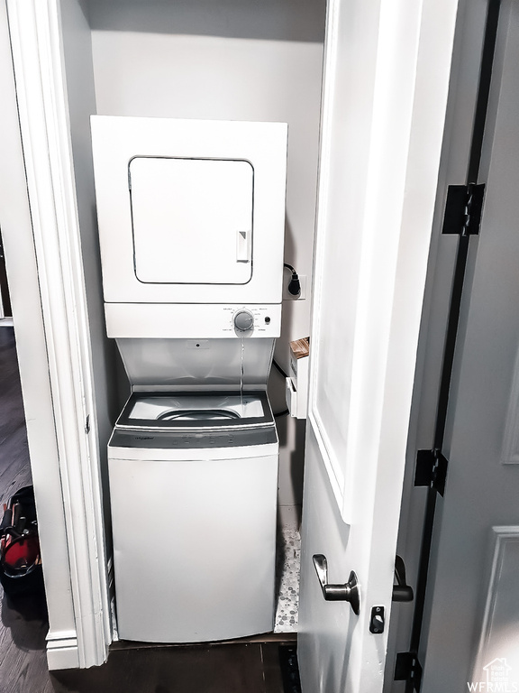 Laundry room with dark hardwood / wood-style flooring, hookup for an electric dryer, and stacked washer / dryer
