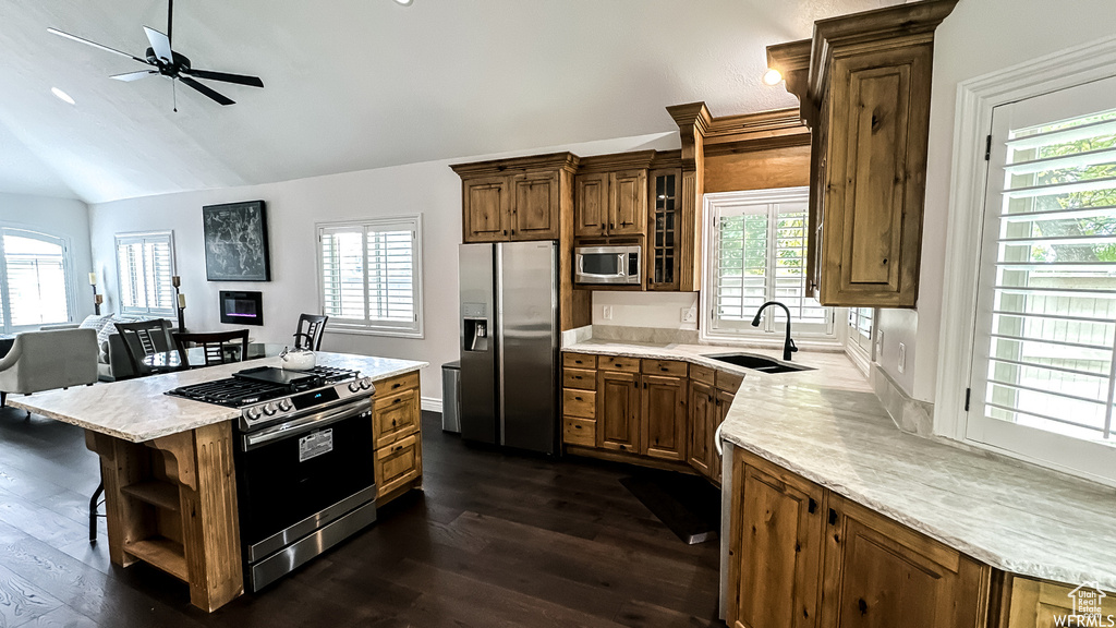 Kitchen with dark wood-type flooring, ceiling fan, appliances with stainless steel finishes, and sink