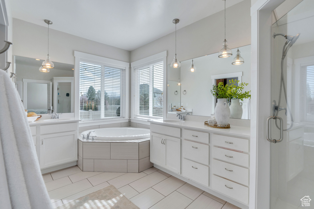Bathroom featuring tile floors, vanity with extensive cabinet space, and independent shower and bath