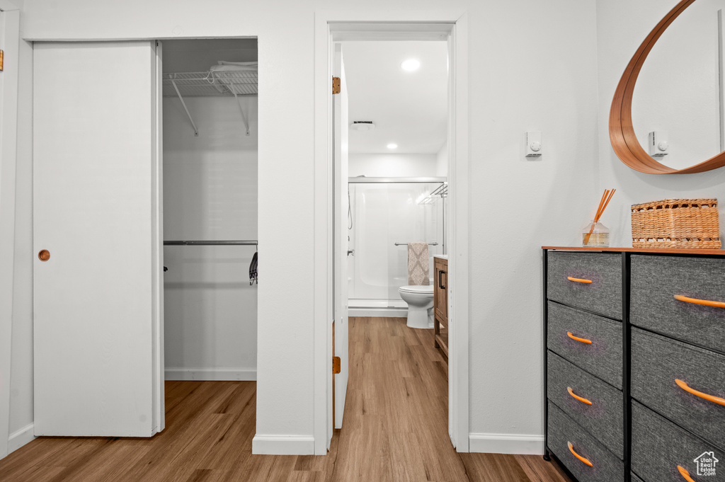Interior space with ensuite bath, a closet, and light wood-type flooring