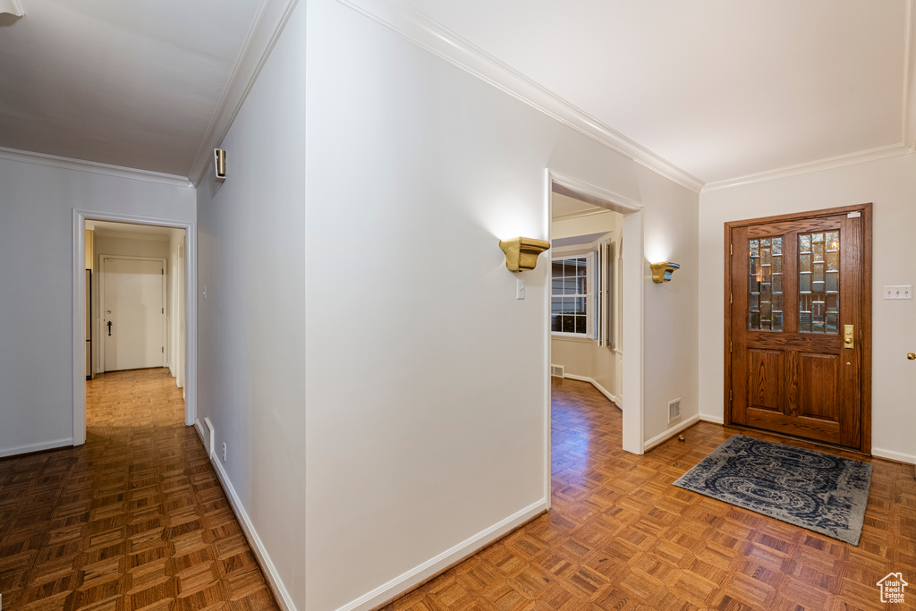 Foyer entrance featuring light parquet flooring and ornamental molding