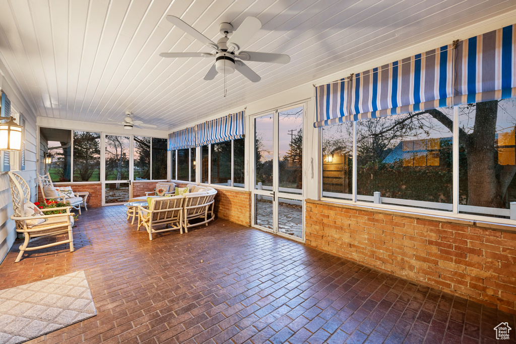 Unfurnished sunroom featuring ceiling fan and wooden ceiling